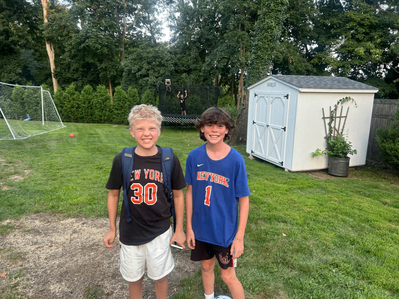 Hamish standing with a friend in a backyard