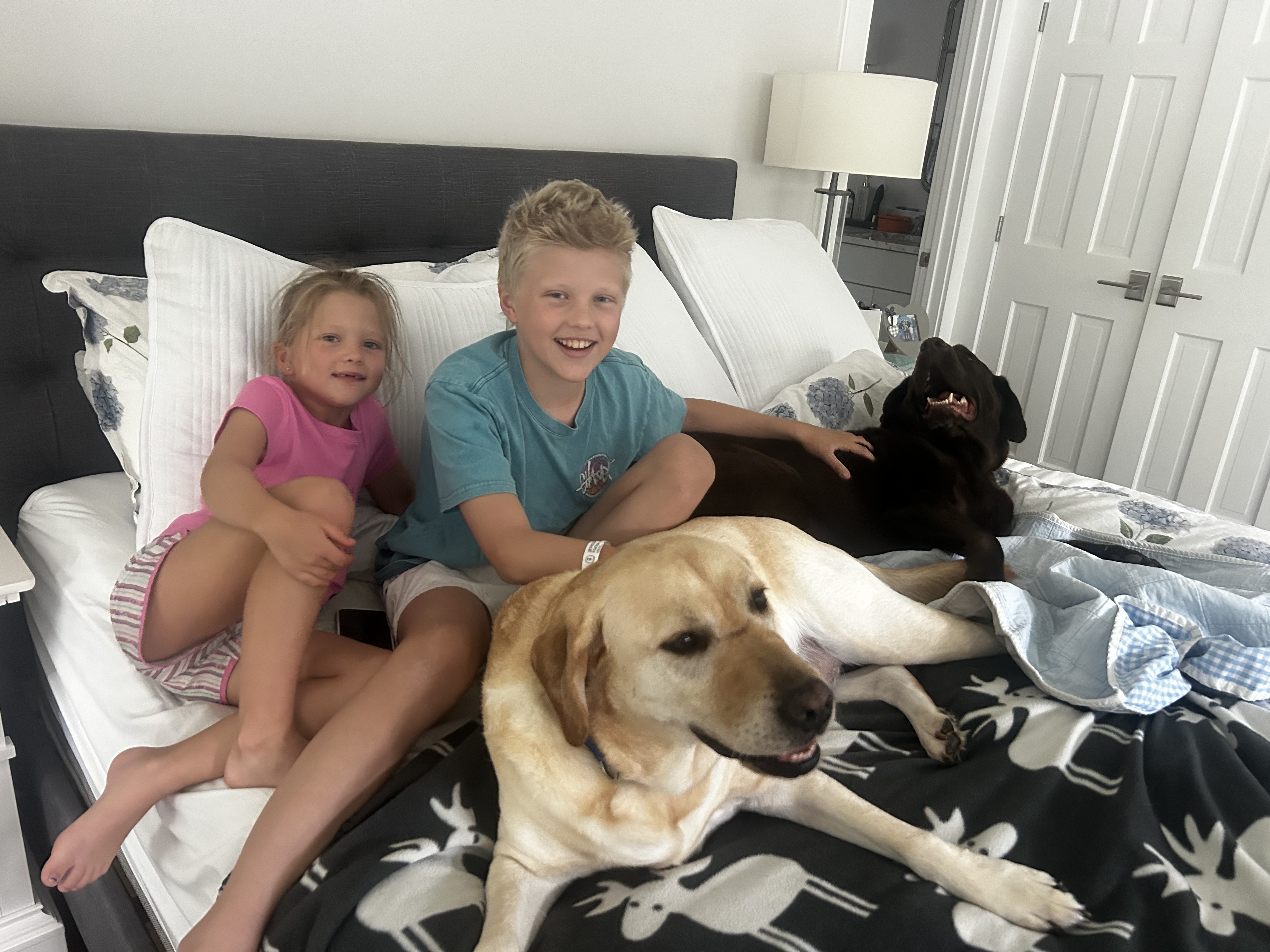 Hamish smiling beside a family member on an airplane
