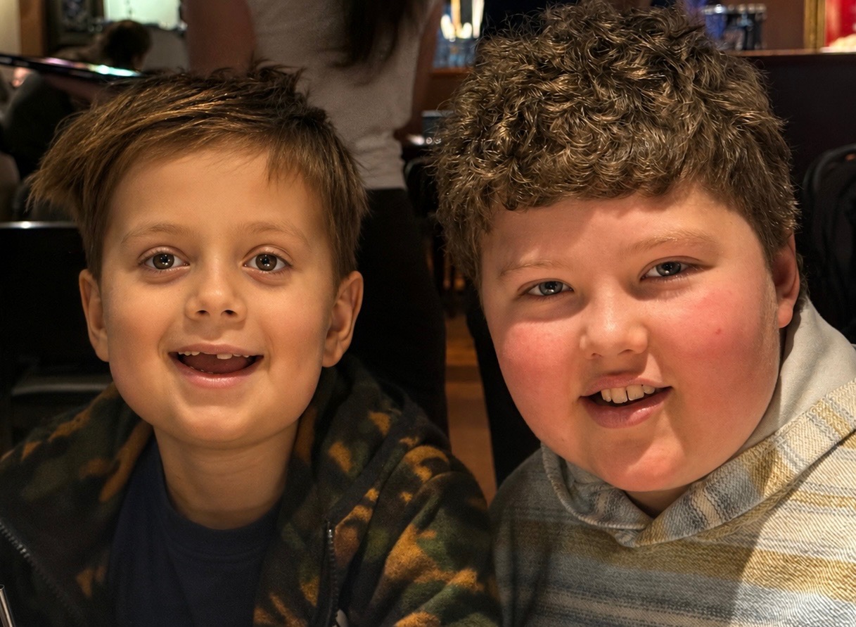Hamish smiling close together with a friend